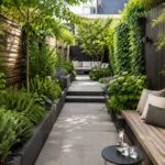 Smalle tuin met dieptewerking, groene beplanting, strak tegelpad, houten bank en rustige zithoek achterin